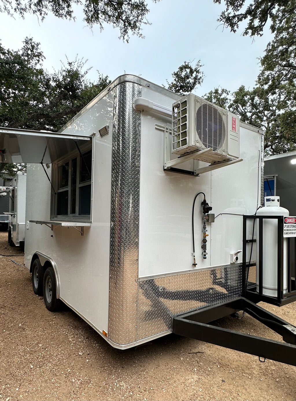 14 FT Burger Trailer showing the mini split condenser and the propane tank cage mounted on the tongue