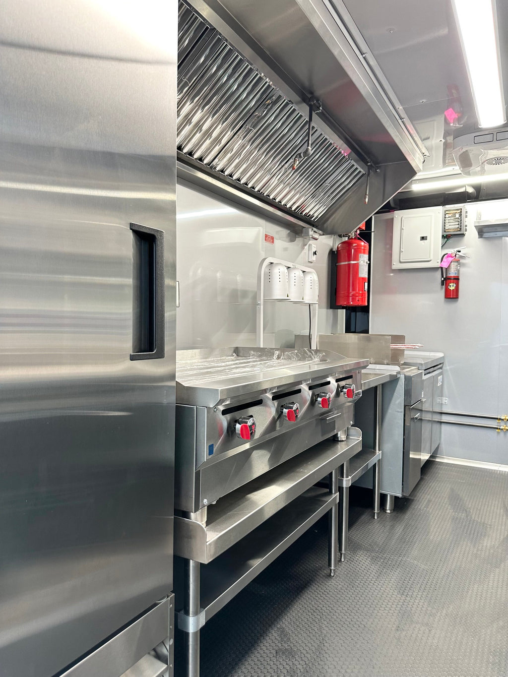 48 inch griddle under the stainless vent hood with Buckeye fire suppression in the 14 FT Burger Trailer