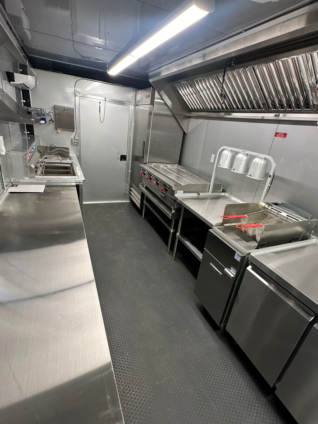 Full-height reach-in refrigerator next to the griddle line in the 14 FT Burger Trailer