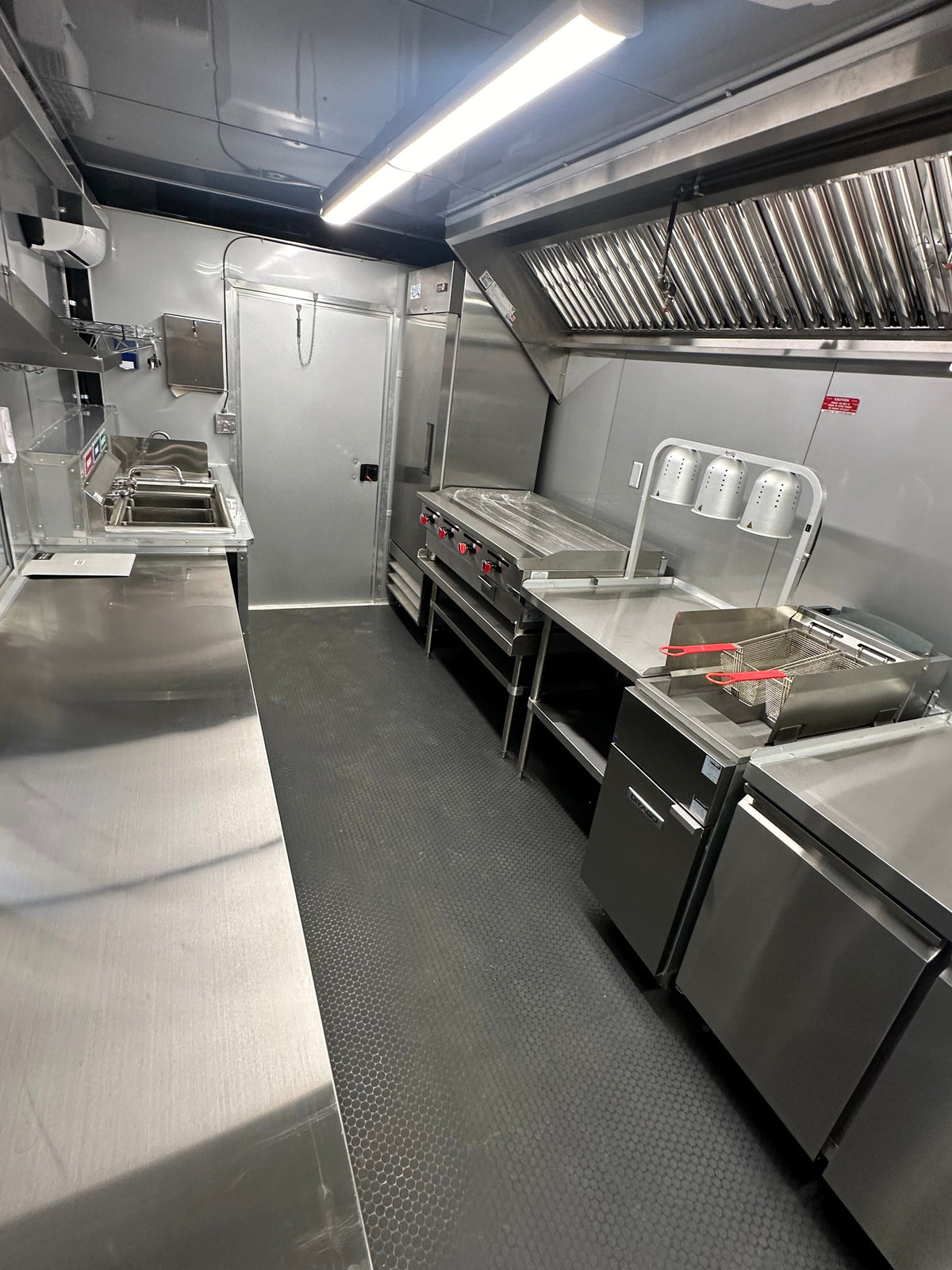Full-height reach-in refrigerator next to the griddle line in the 14 FT Burger Trailer