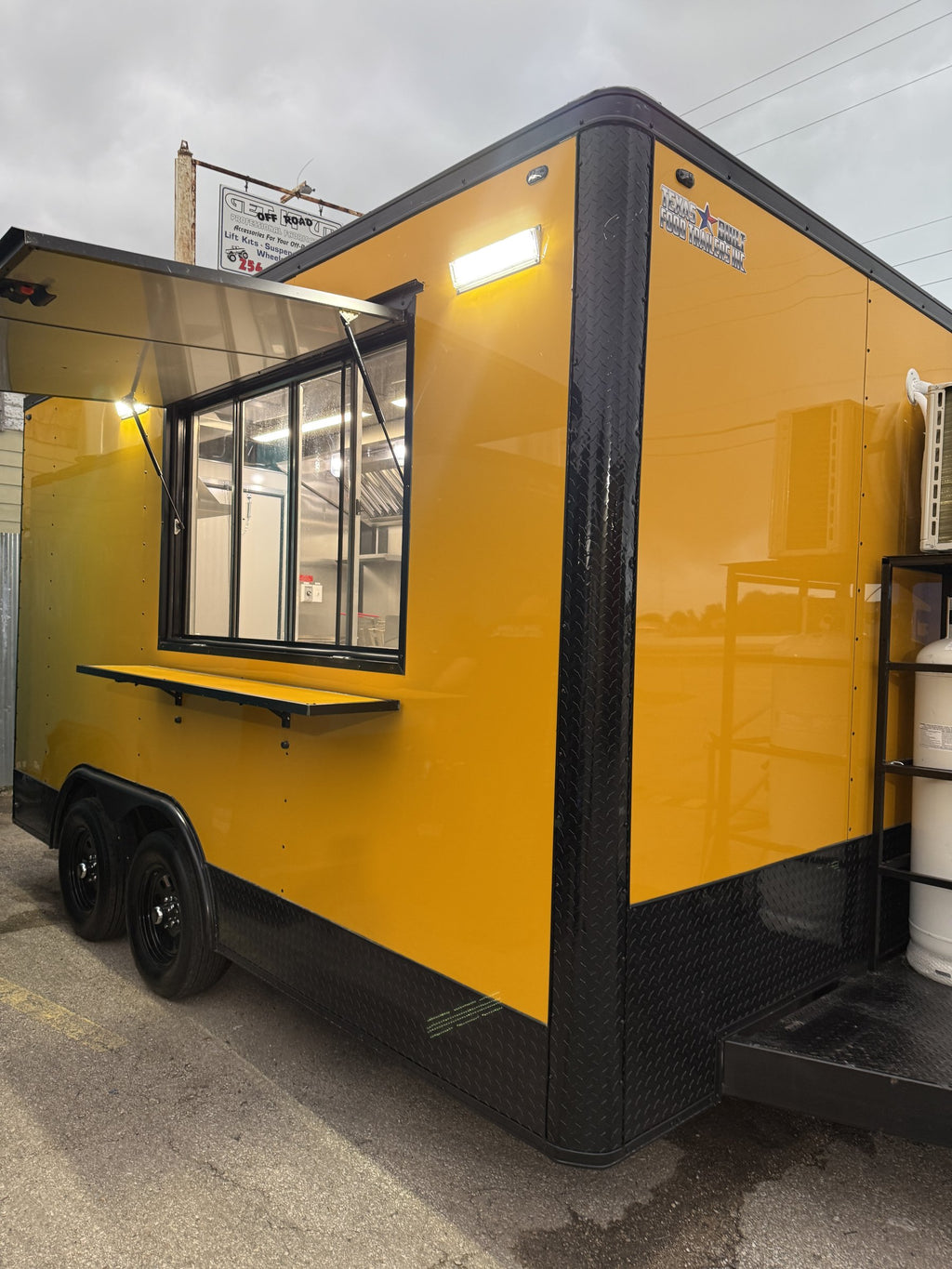 14 FT yellow cooking trailer, exterior three-quarter view with the concession window open