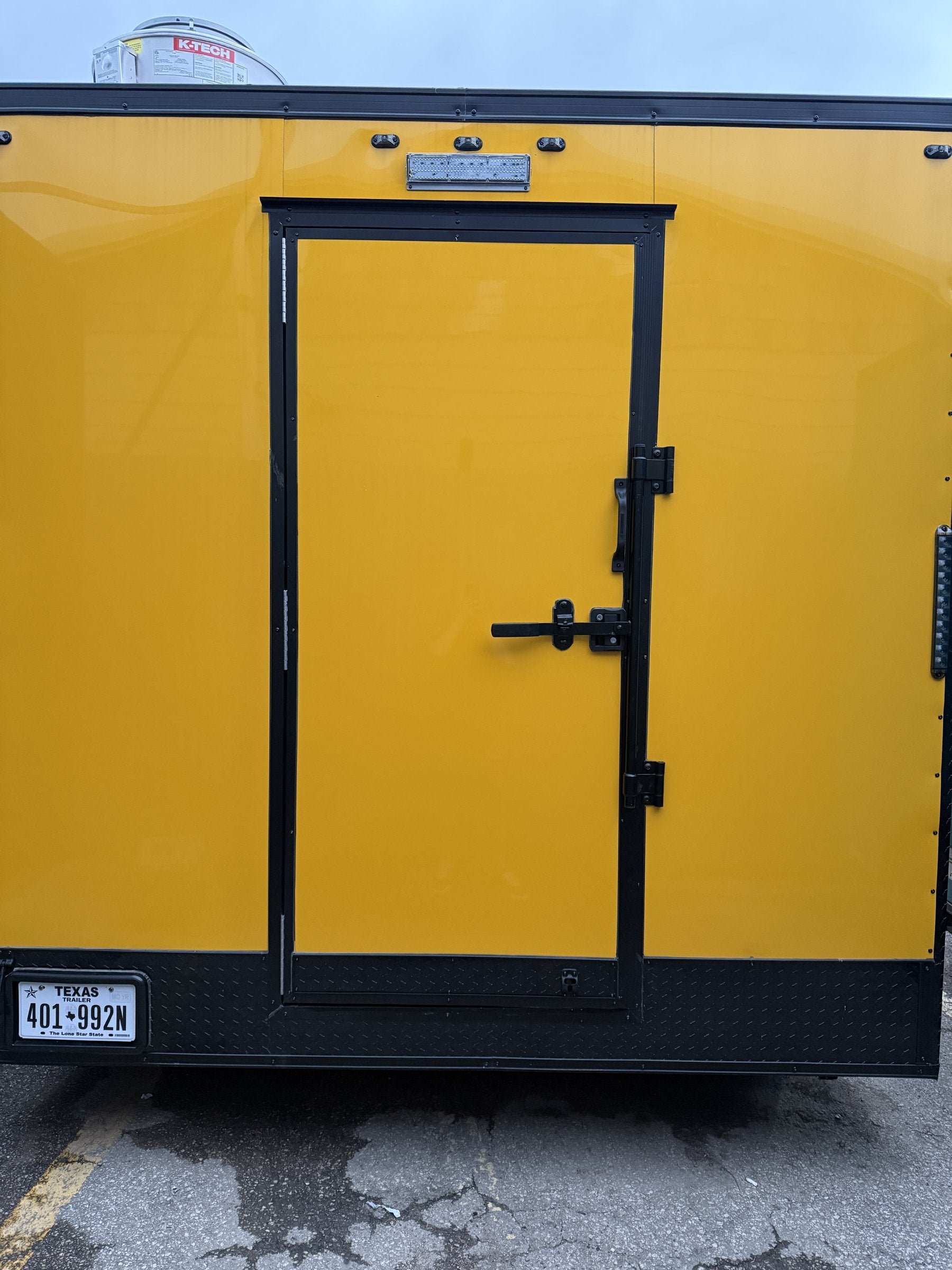 14 FT yellow cooking trailer, exterior rear with entry door