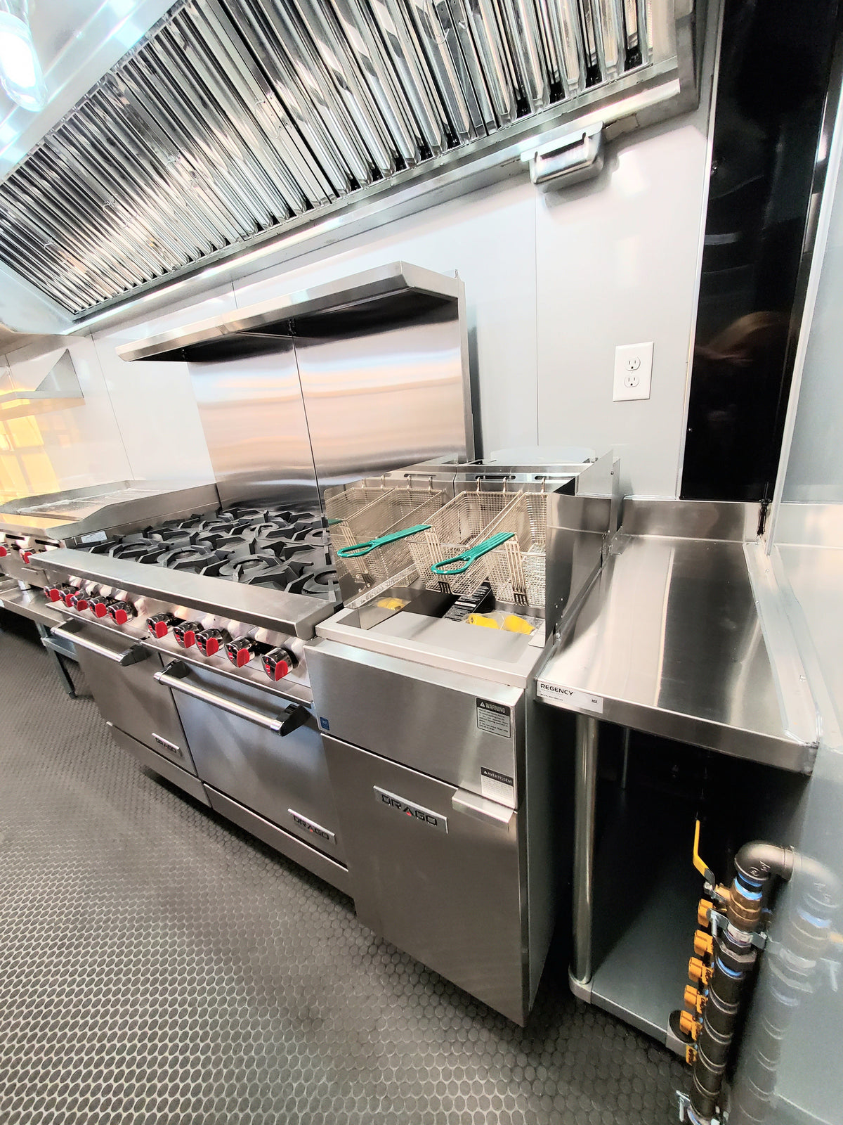 Stainless steel commercial kitchen with large stove and exhaust hood