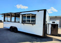 White food truck with black windows on a clear day