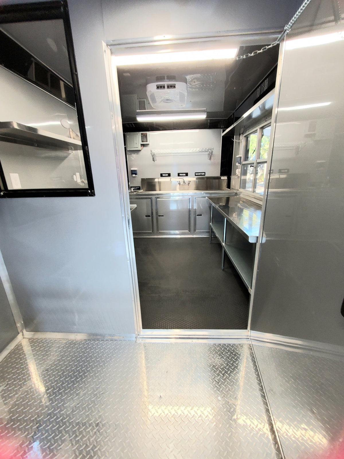 Interior of a food truck with stainless steel appliances and counters.