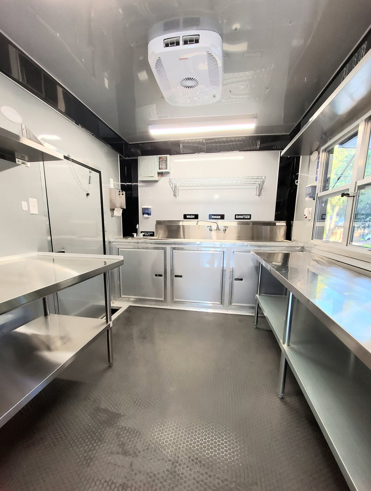 Modern kitchen trailer interior with stainless steel counters and cabinets.