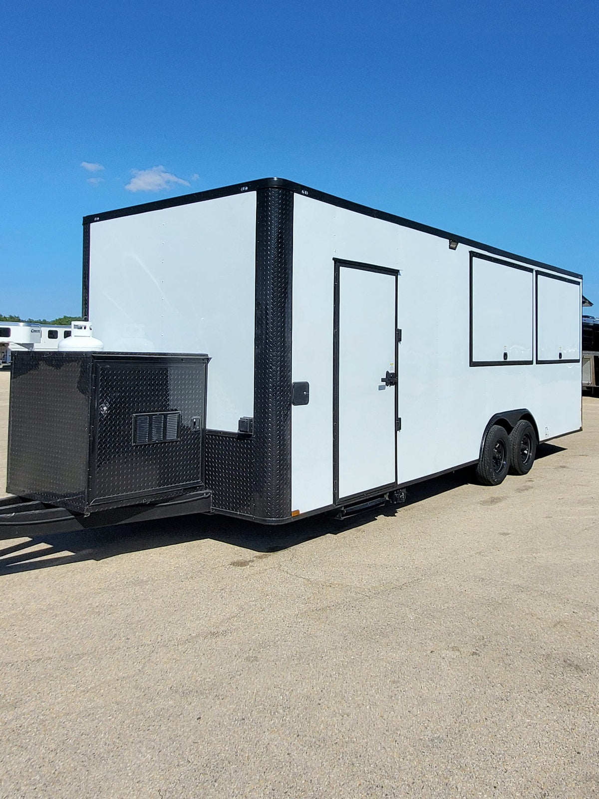White enclosed trailer with a door on a clear day