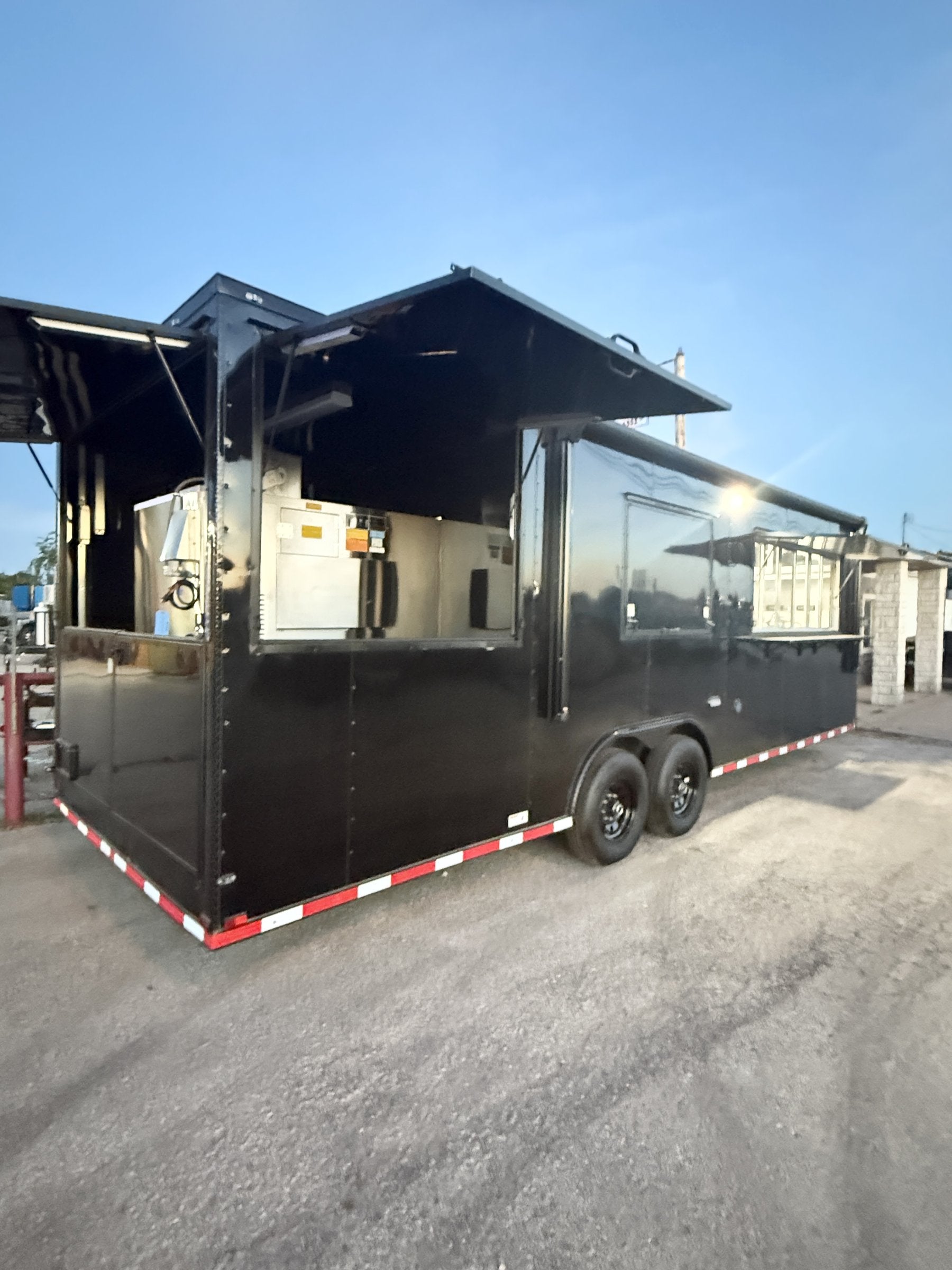 26 FT concession porch trailer, fully loaded, exterior three-quarter at dusk, serving side lit