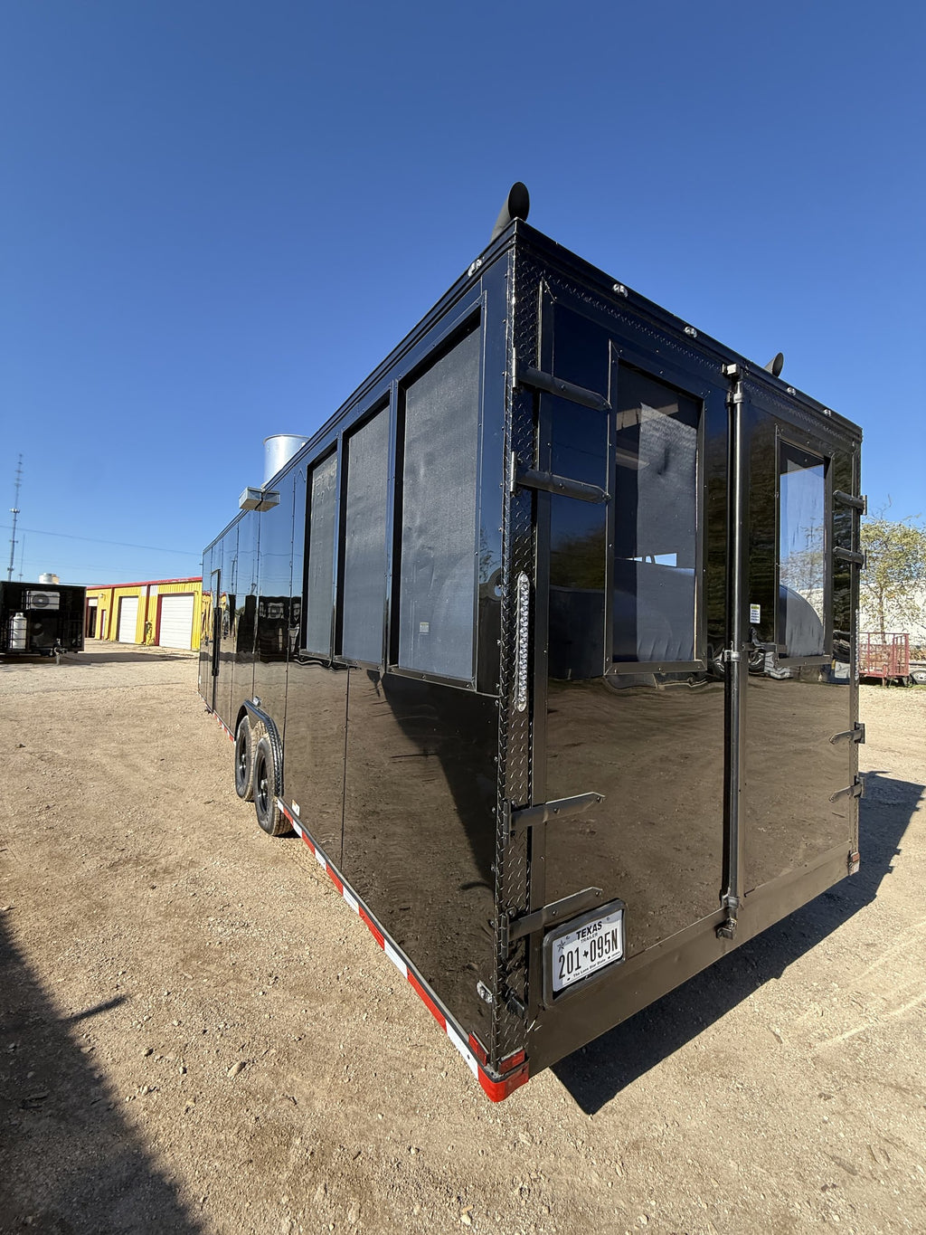 28 FT smoker concession trailer with restroom, exterior three-quarter with serving windows and smoker stack