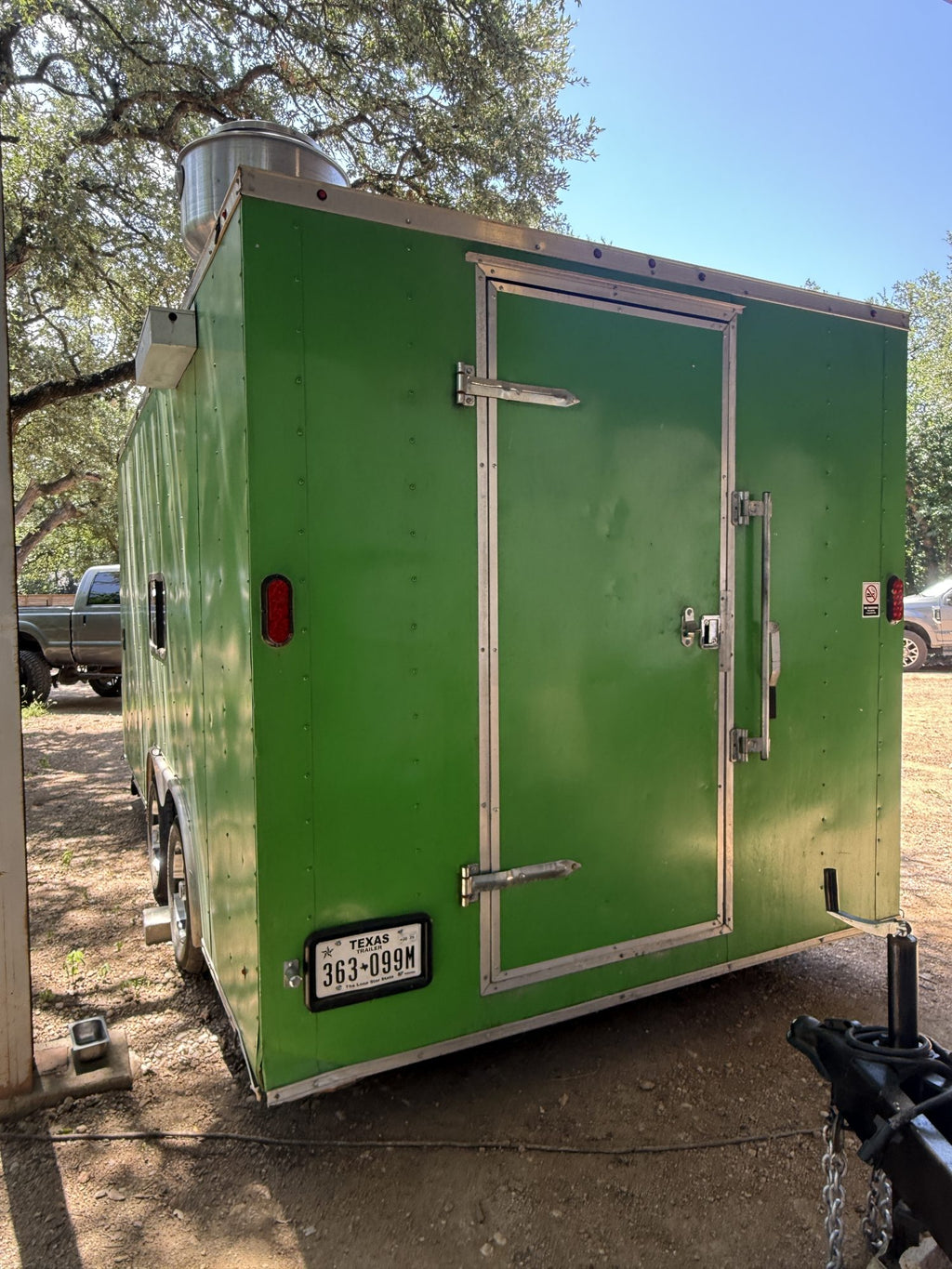 Rear of the green concession trailer showing the door and licence plate