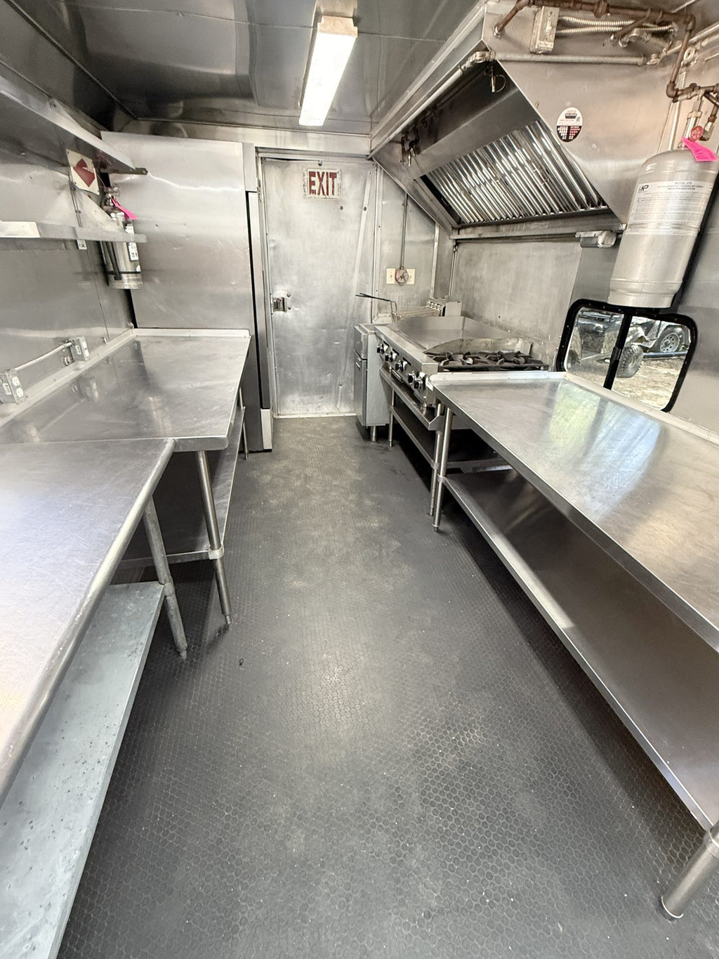 Interior looking toward the rear door, stainless prep counters down both sides and a fire extinguisher by the exit