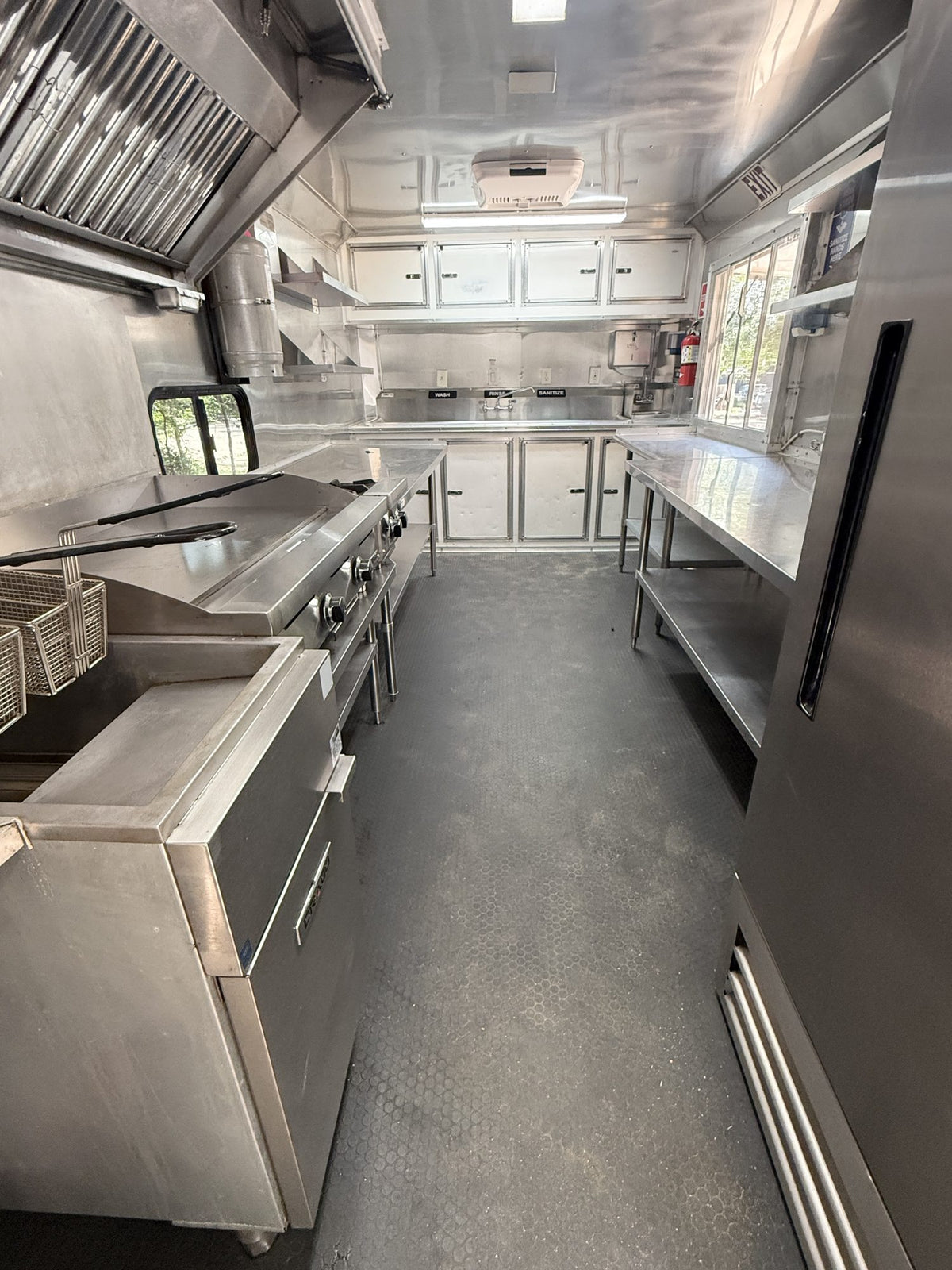 Interior cook line with deep fryer, griddle and hot plate under the vent hood