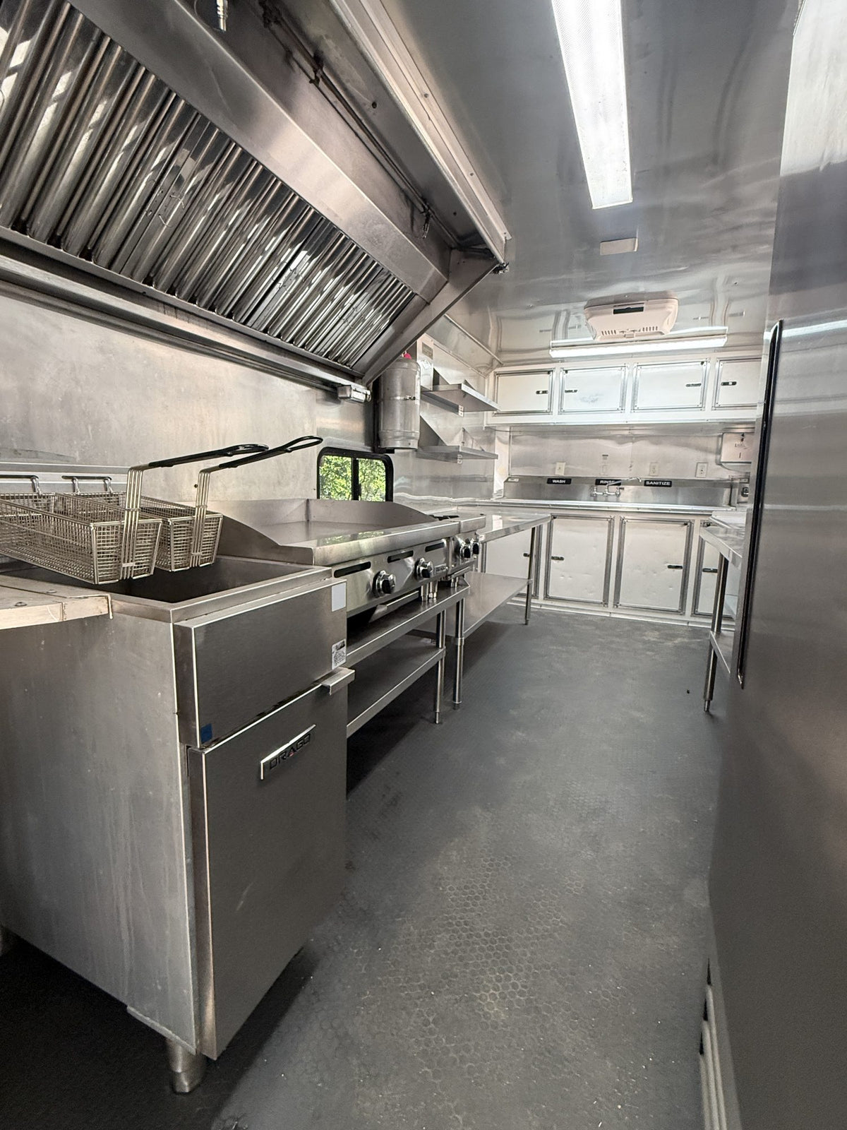 Deep fryer with baskets beside the stainless prep counter