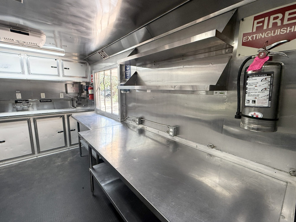 Stainless prep counter and shelving along the service side of the trailer
