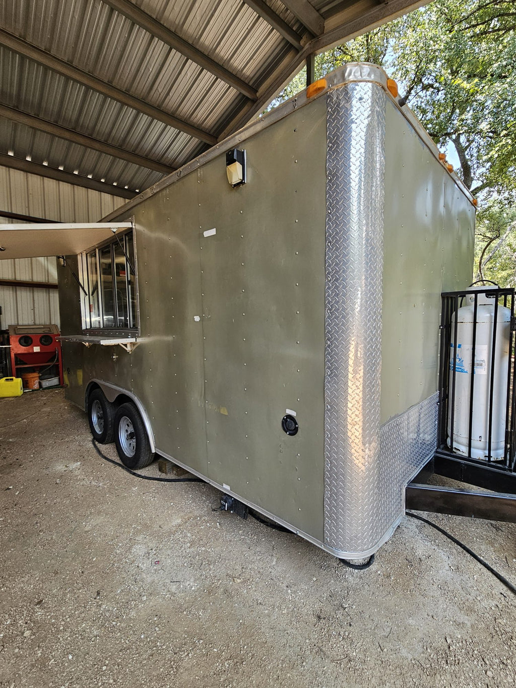 Full side view of the silver concession trailer with the serving window closed