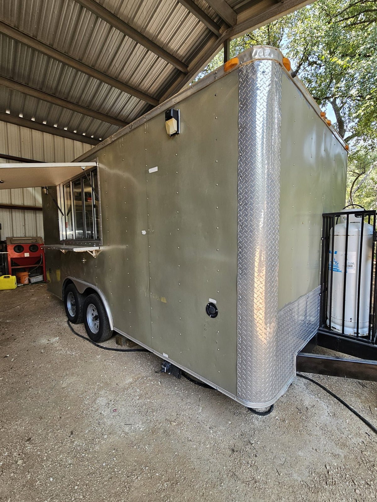 Full side view of the silver concession trailer with the serving window closed