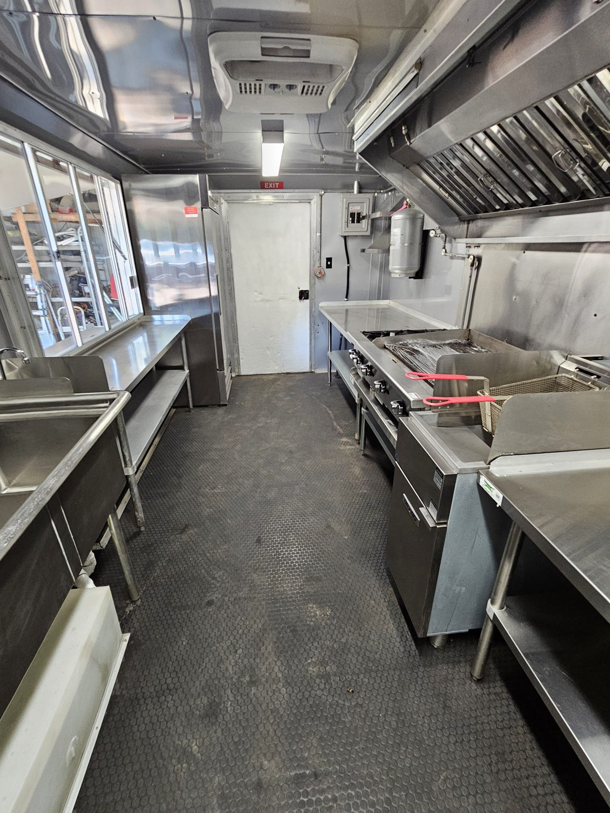 Interior view toward the serving window with overhead menu boards and prep counter