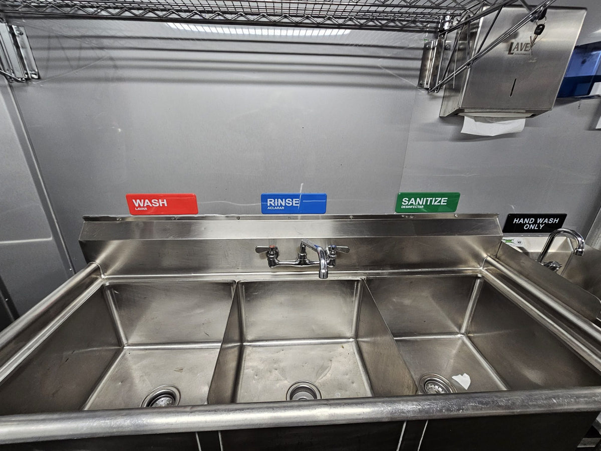 Three compartment sink with wash, rinse and sanitize labels