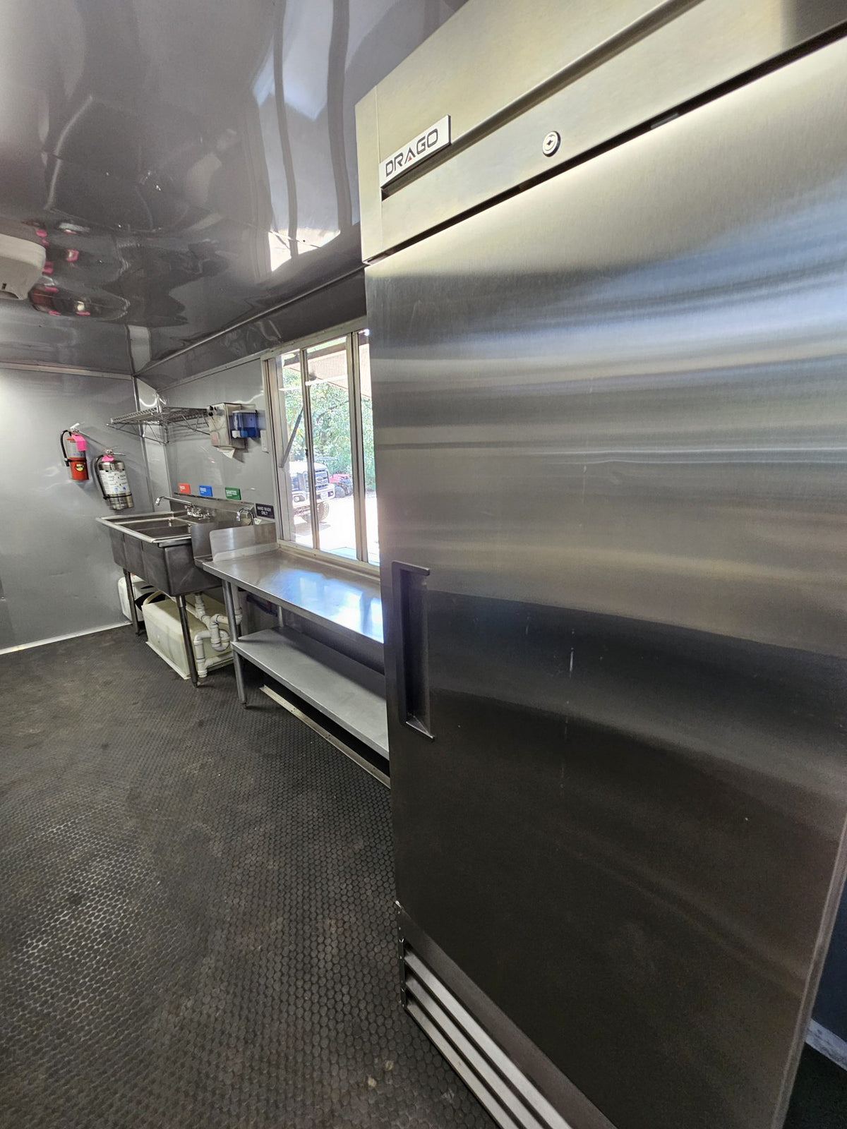 Upright stainless reach-in refrigerator inside the trailer
